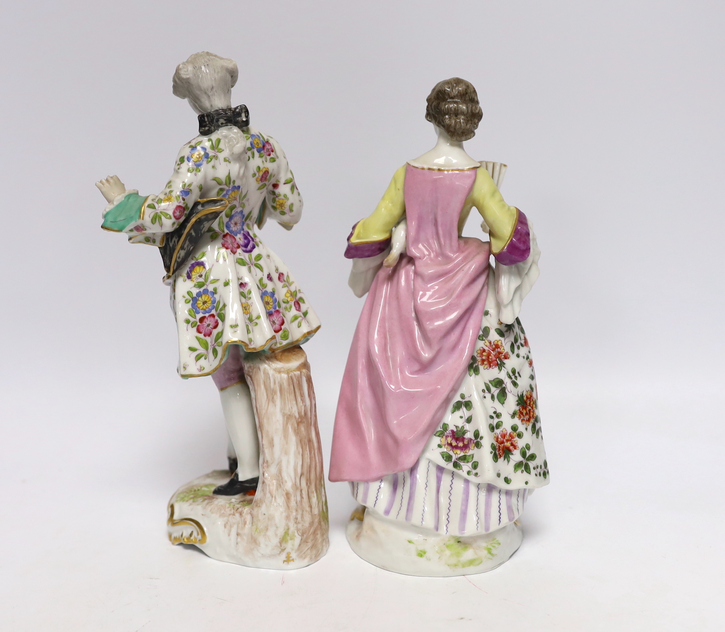 A pair of Continental porcelain figures wearing 18th century dress, largest 24cm high